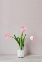 buquê de três tulipas cor de rosa fica em um vaso de vidro com renda. o conceito do festival da primavera foto