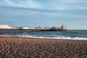 pessoas andando pelo calçadão perto da praia em Brighton. foto