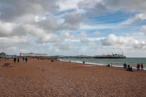 pessoas andando pelo calçadão perto da praia em Brighton. foto