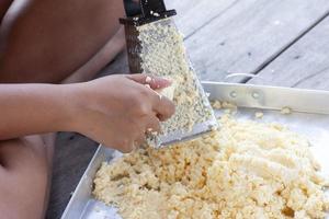 mão de mulheres coçando uma batata para cozinhar alimentos. foto