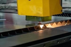 máquina de corte a laser, cortando folhas de madeira, enquanto um homem cuida do processo, américa latina foto