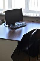 computador pessoal na mesa do escritório. monitore o teclado e o mouse em cima da mesa. foto