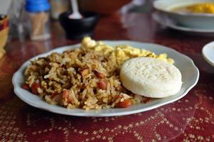 arroz com feijão preto servido com omelete e arepa, comida colombiana foto