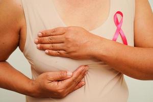 mulher asiática com fita rosa, dia mundial do câncer de mama em outubro. foto