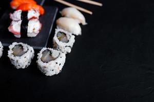 comida de sushi japonesa. maki ands rolls com atum, salmão, camarão, caranguejo e abacate. vista superior de sushis variados. foto