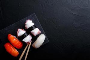comida de sushi japonesa. maki ands rolls com atum, salmão, camarão, caranguejo e abacate. vista superior de sushis variados. foto