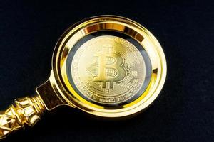 fundo preto de bitcoin e lupa foto