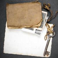 chave enferrujada, livro antigo e fotografia vazia foto
