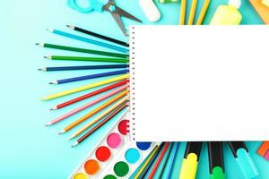 um álbum para desenvolvimento criativo na escola, com papel timbrado em fundo de cianeto. uma paleta de tintas coloridas, marcadores, pincéis e lápis. foto