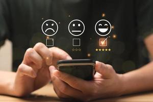 conceito de satisfação do cliente. mãos de homens de negócios usando um celular para comentar 5 estrelas. índice de satisfação, bom e impressionante, serviço pós-venda. excelente classificação de negócios, reputação foto