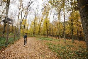 menino em uma caminhada na floresta de outono. foto