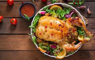 frango assado recheado com arroz para o jantar de Natal em uma mesa festiva foto