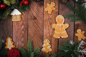 biscoitos de natal e enfeites em um fundo escuro de madeira. vista do topo. postura plana foto