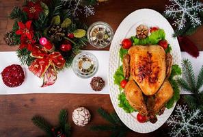 peru ou frango assado. a mesa de natal é servida com um peru, decorado com enfeites brilhantes e velas. frango frito, mesa. ceia de Natal. postura plana. vista do topo foto