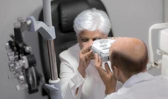 mulheres idosas têm seus olhos examinados por um oftalmologista. foto