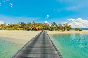 panorama incrível nas maldivas. Seascape de cais de villas resort de luxo com palmeiras, areia branca e céu azul. bela paisagem de verão. fundo de praia tropical para férias de férias. ilha paradisíaca foto