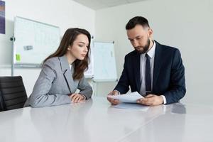 trabalhadores agrícolas estudando um documento sentado em uma mesa em uma sala de reuniões foto