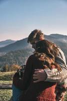 relacionamentos próximos. lindo casal jovem tomando café da manhã enquanto passa um tempo despreocupado nas montanhas foto