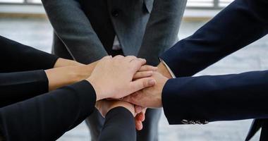 close-up empresários juntando as mãos. conceito de unidade e trabalho em equipe foto