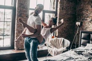 louco de amor. jovem casal apaixonado se divertindo juntos e parecendo feliz enquanto jovem bonito carregando sua namorada nos ombros foto