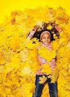 menina africana coberta com folhas de outono