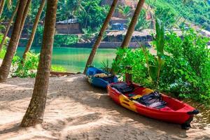 duas canoas à sombra de palmeiras tropicais na praia foto