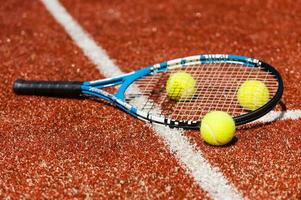 hora de jogar tênis. close-up de raquete de tênis e três bolas de tênis na quadra foto
