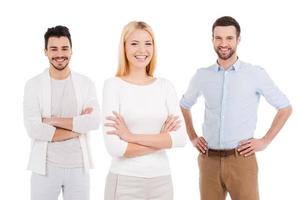 jovem e cheio de novas ideias. três jovens confiantes em roupas casuais inteligentes, olhando para a câmera e sorrindo em pé contra um fundo branco foto