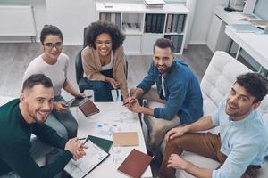 vista superior de jovens modernos em roupas casuais inteligentes, olhando para a câmera e sorrindo foto