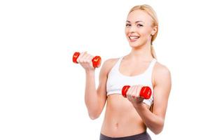 apaixonado pelo esporte. belas mulheres maduras segurando halteres e sorrindo em pé contra um fundo branco foto