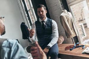 longa jornada de trabalho. dois jovens elegantes discutindo enquanto passavam o tempo na oficina foto