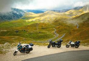paisagem com estrada de montanha e três motos foto