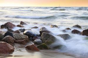 a praia de seixos ao pôr do sol - rozewie, polônia, longa exposição foto