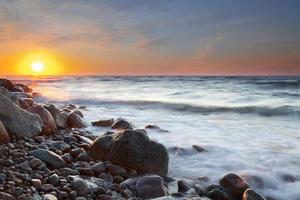a praia de seixos ao pôr do sol - rozewie, polônia, longa exposição foto