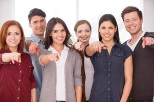 você se juntará ao nosso grupo de jovens alegres próximos uns dos outros e apontando para você foto