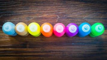 tinta colorida - garrafas com pigmentos coloridos em fundo de madeira