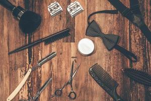 ferramentas de barbeiro. vista superior de ferramentas de barbearia e acessórios masculinos deitados no grão de madeira foto