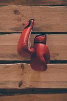 luvas de boxe na parede. close-up de luvas de boxe penduradas na parede de madeira vintage foto