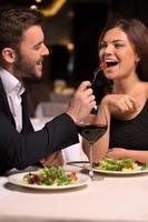 é delicioso lindo casal jovem se alimentando e sorrindo enquanto passa o tempo no restaurante foto