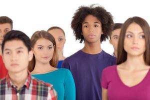 solidão na multidão. adolescente africano frustrado em pé entre as pessoas e desviar o olhar foto