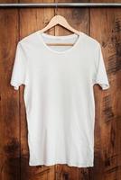 camiseta branca. close-up de camiseta branca pendurada contra grão de madeira foto