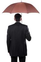 empresário com guarda-chuva. vista traseira do homem maduro em trajes formais segurando guarda-chuva em pé contra um fundo branco foto
