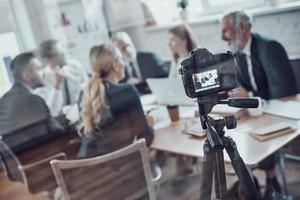 equipe de negócios moderna discutindo estratégia enquanto filmava reunião de equipe na sala de reuniões foto