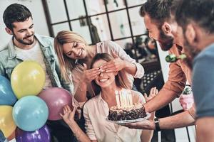 surpresa para ela. grupo de pessoas felizes comemorando aniversário entre amigos e sorrindo enquanto faz uma festa foto