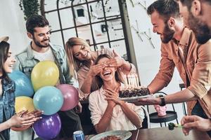 a aniversariante. grupo de pessoas felizes comemorando aniversário entre amigos e sorrindo enquanto faz uma festa foto