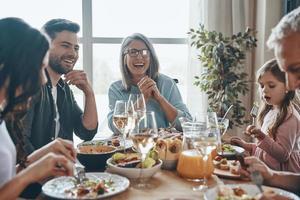 feliz família de várias gerações se comunicando e sorrindo enquanto jantava juntos foto