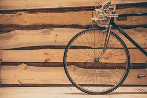 elegância antiquada. close-up de pé de bicicleta com estilo retrô contra a parede de madeira áspera foto