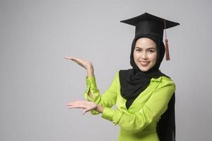 jovem mulher muçulmana sorridente com hijab usando chapéu de formatura, educação e conceito universitário foto
