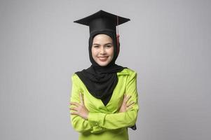 jovem mulher muçulmana sorridente com hijab usando chapéu de formatura, educação e conceito universitário foto