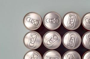 muitas novas latas de alumínio de refrigerantes ou recipientes de bebidas energéticas. conceito de fabricação de bebidas e produção em massa foto